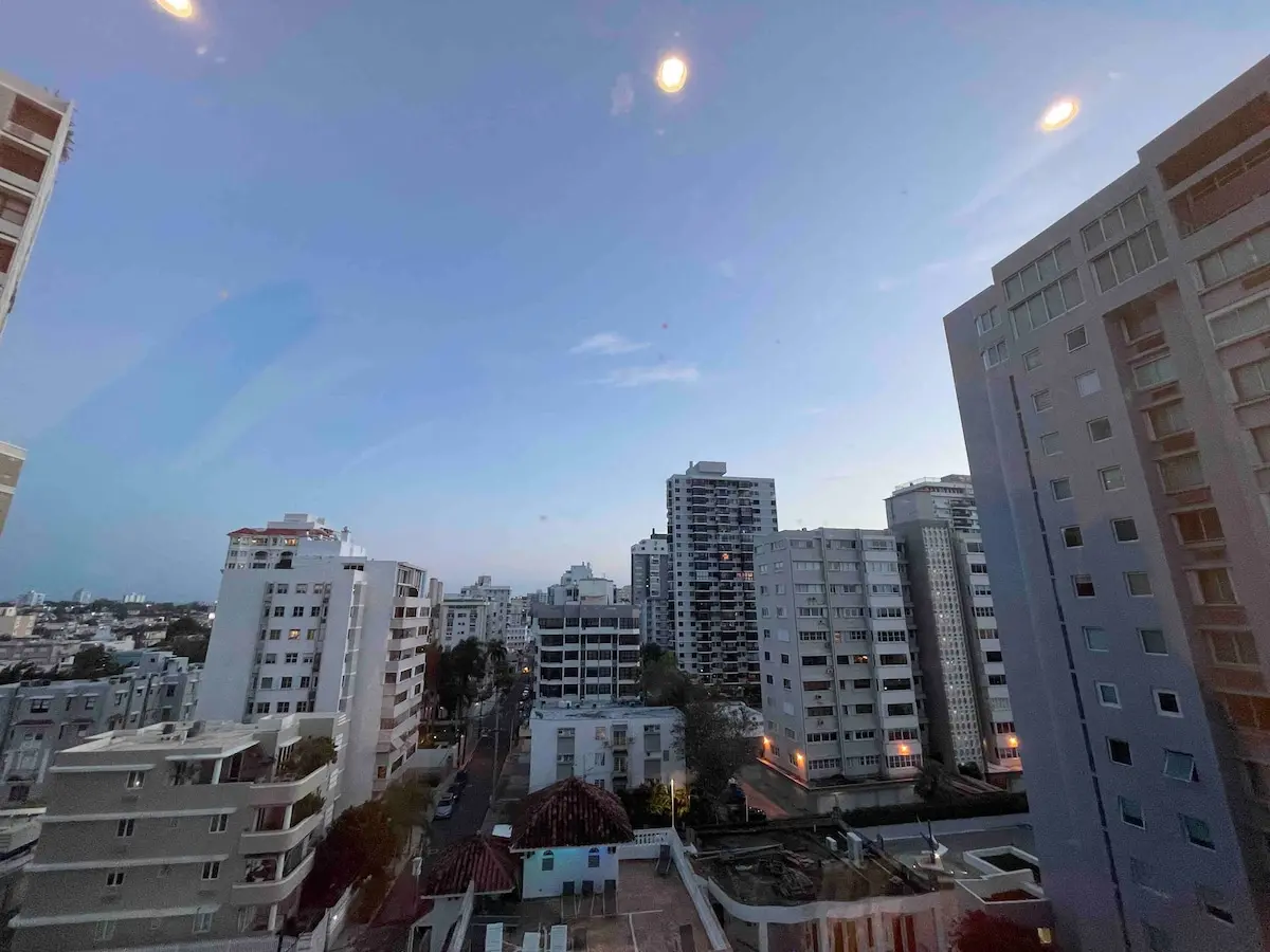 View down onto the Ocean Park neighborhood from a high-floor window, seen through the glass with ceiling light reflections.