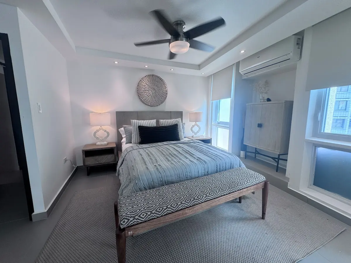 Master bedroom with a king bed, ceiling fan, split air conditioning and a dresser.